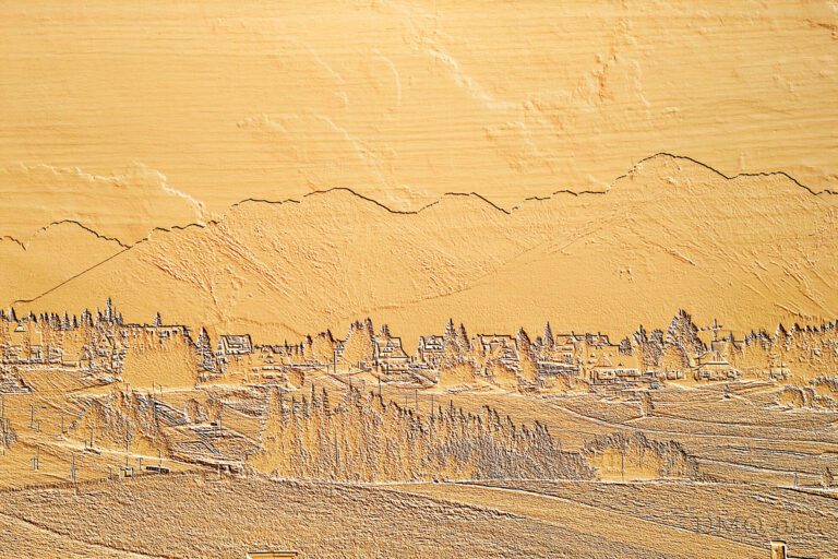 A fragment of a panorama with a view of the mountains in Slovakia carved in wood